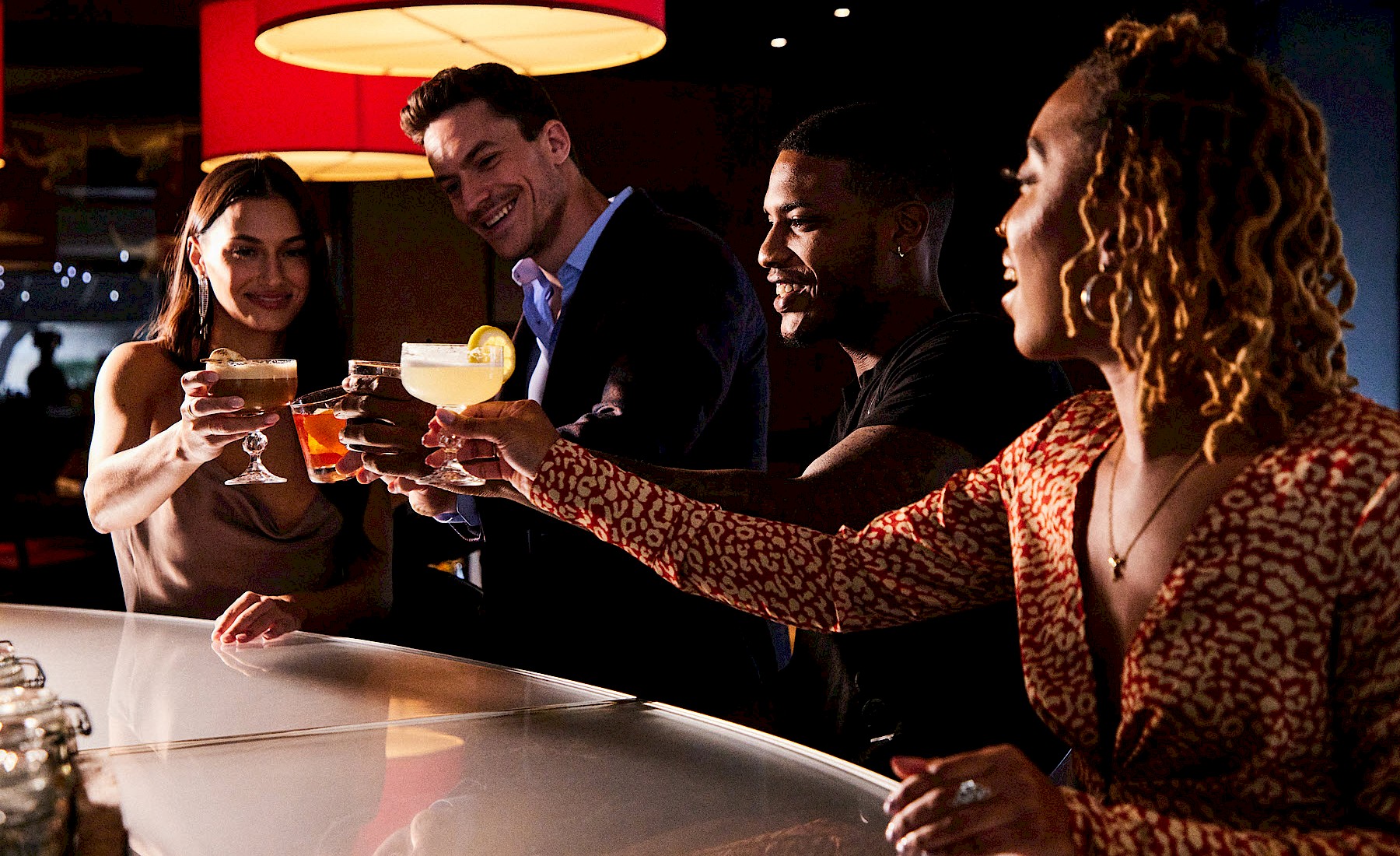 People cheersing drinks at a bar at Hotel Derek